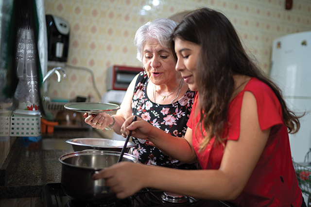 Young woman cooking with older woman